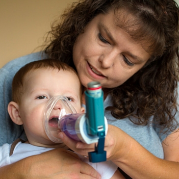 Niño con asma. Cámara de inhalación con mascarilla nasal.